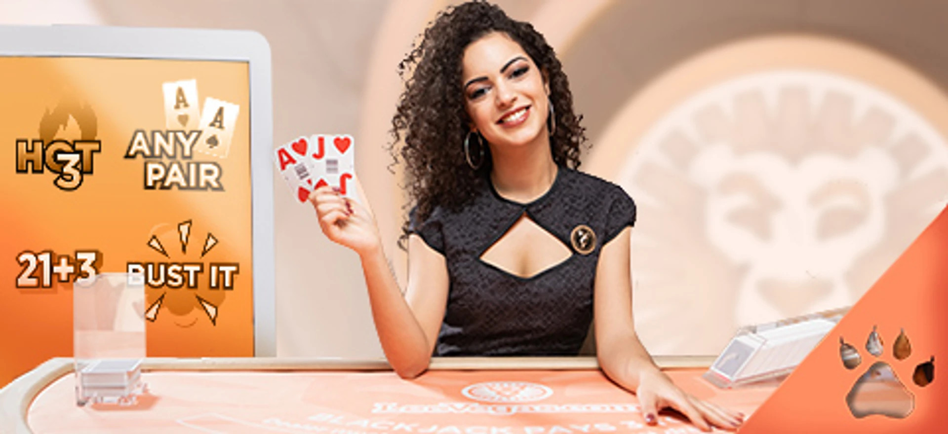 Dealer ved blackjack-bord viser kortene A og J, omgivet af sidebets som '21+3' og 'Bust It