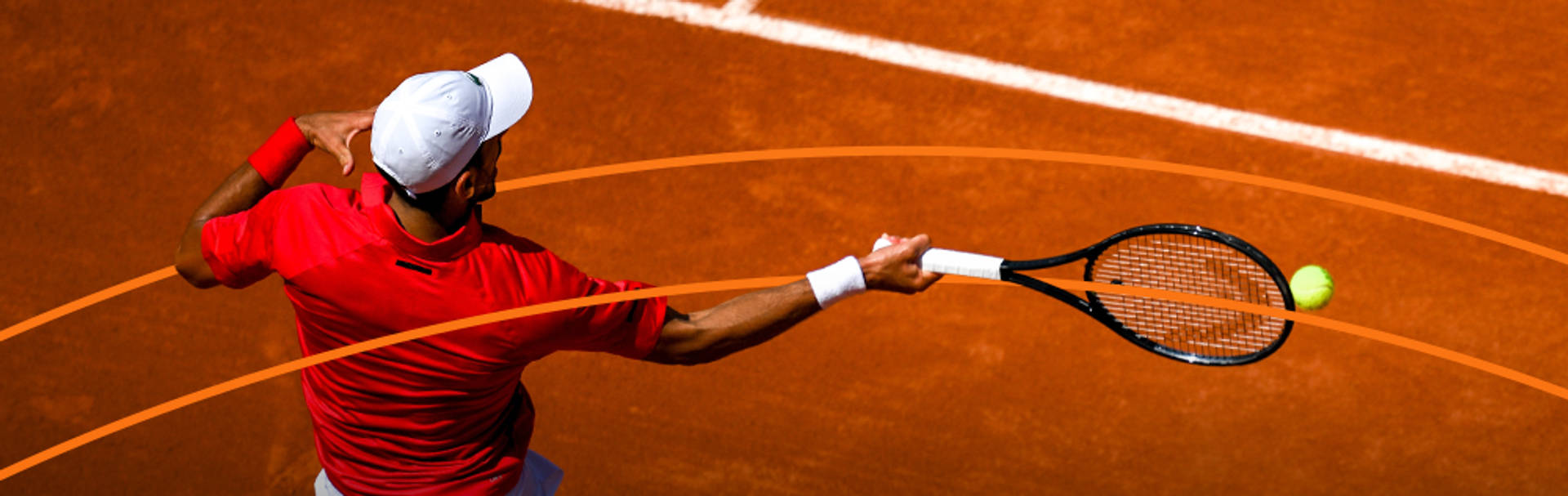 Jugador de tenis golpeando la pelota en una cancha de tierra batida.
