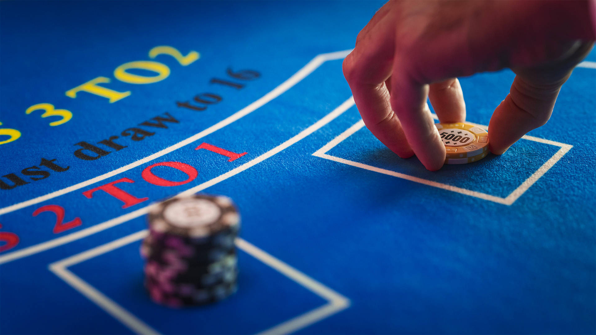 hand placing chips on a blackjack table