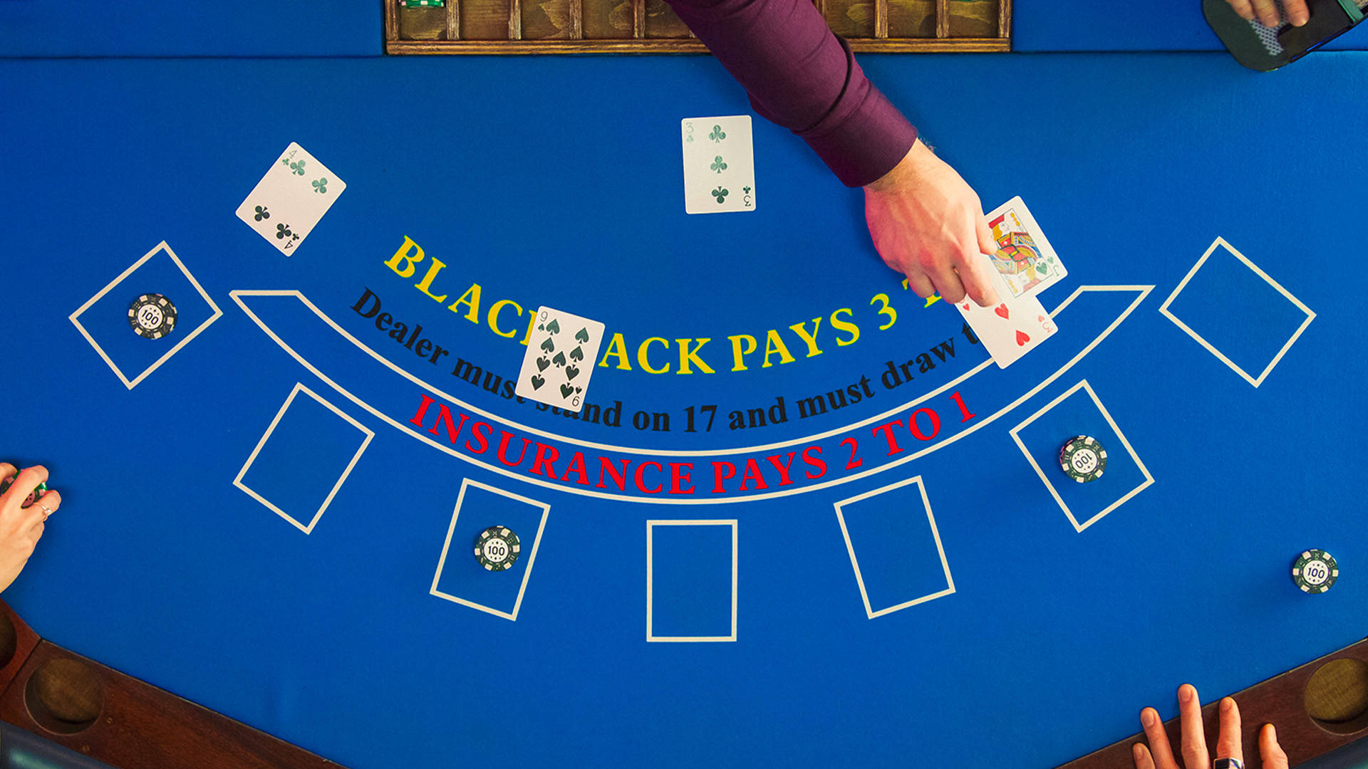 view looking down on a blackjack table with dealing handing out cards