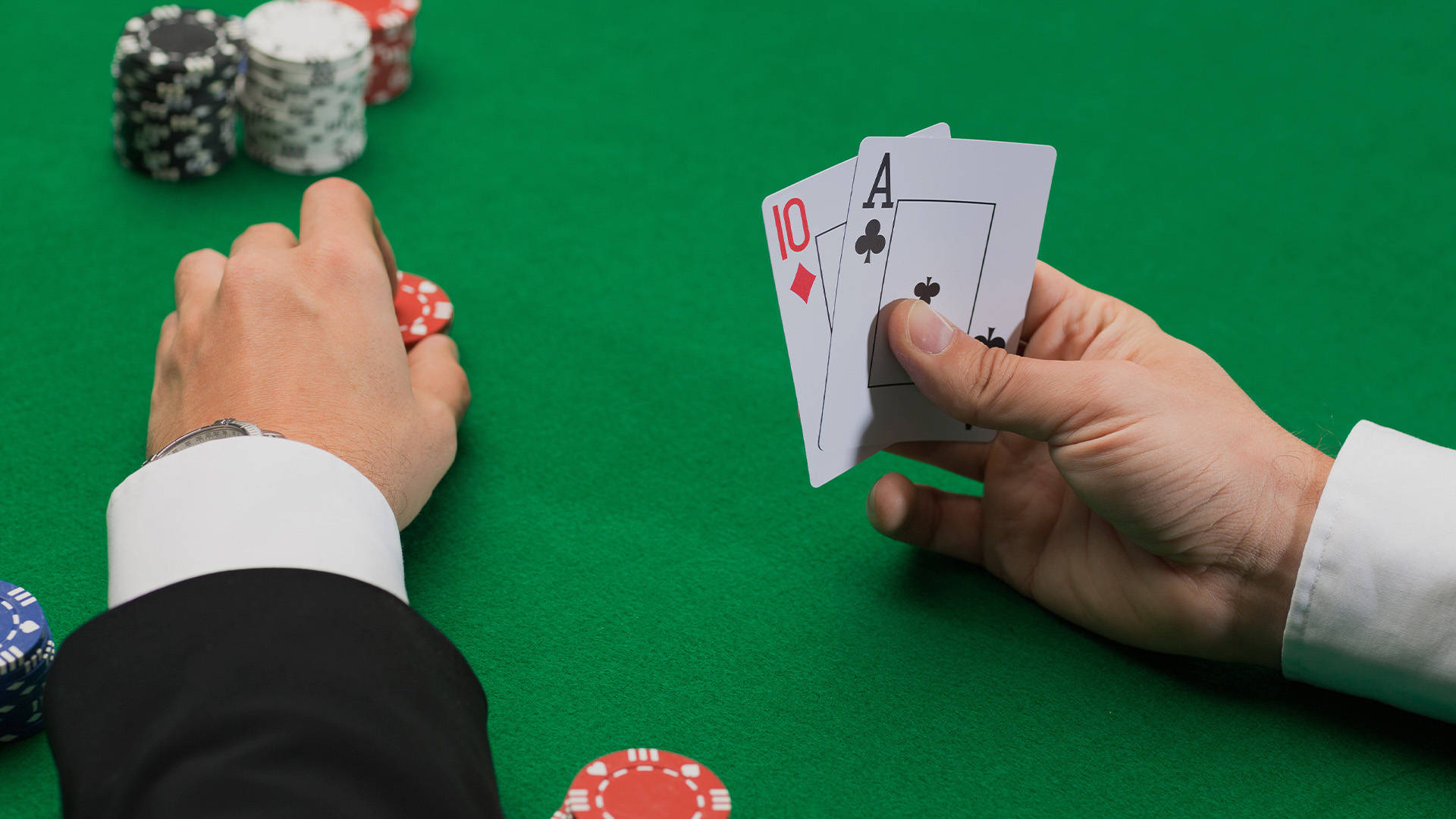 player holding two cards with one hand and placing chips with the other