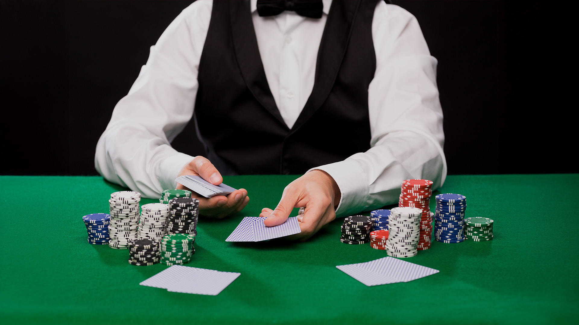 poker dealer handing out cards in pairs