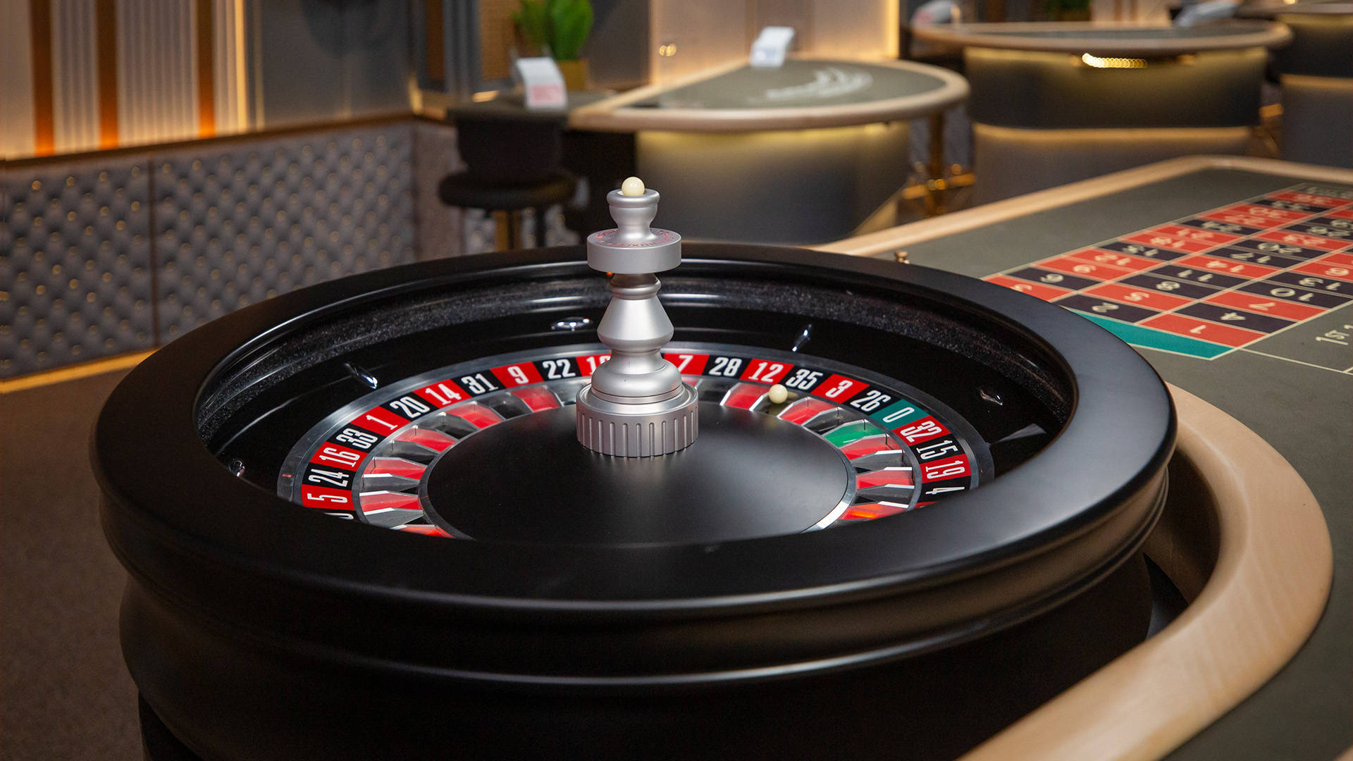 roulette wheel and table with the ball sitting in the black pocket