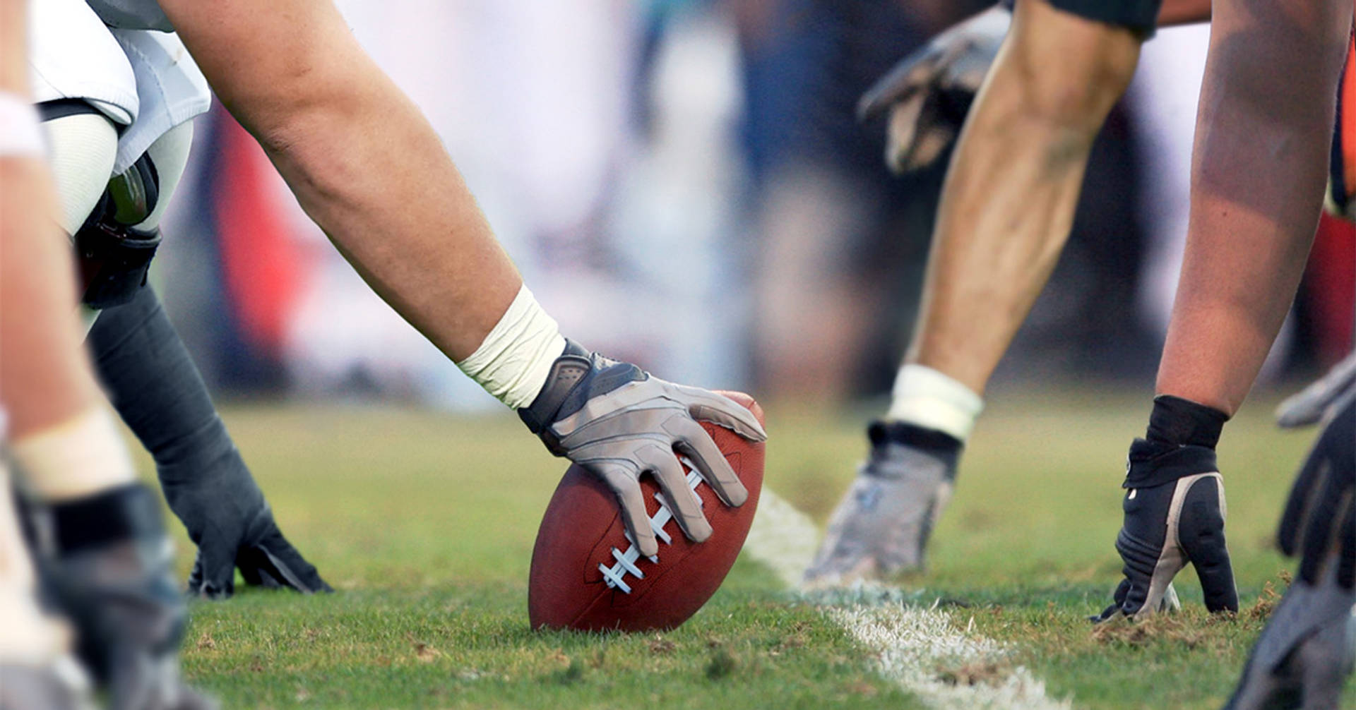 football player placing ball down at the line of scrimmage ready for the snap
