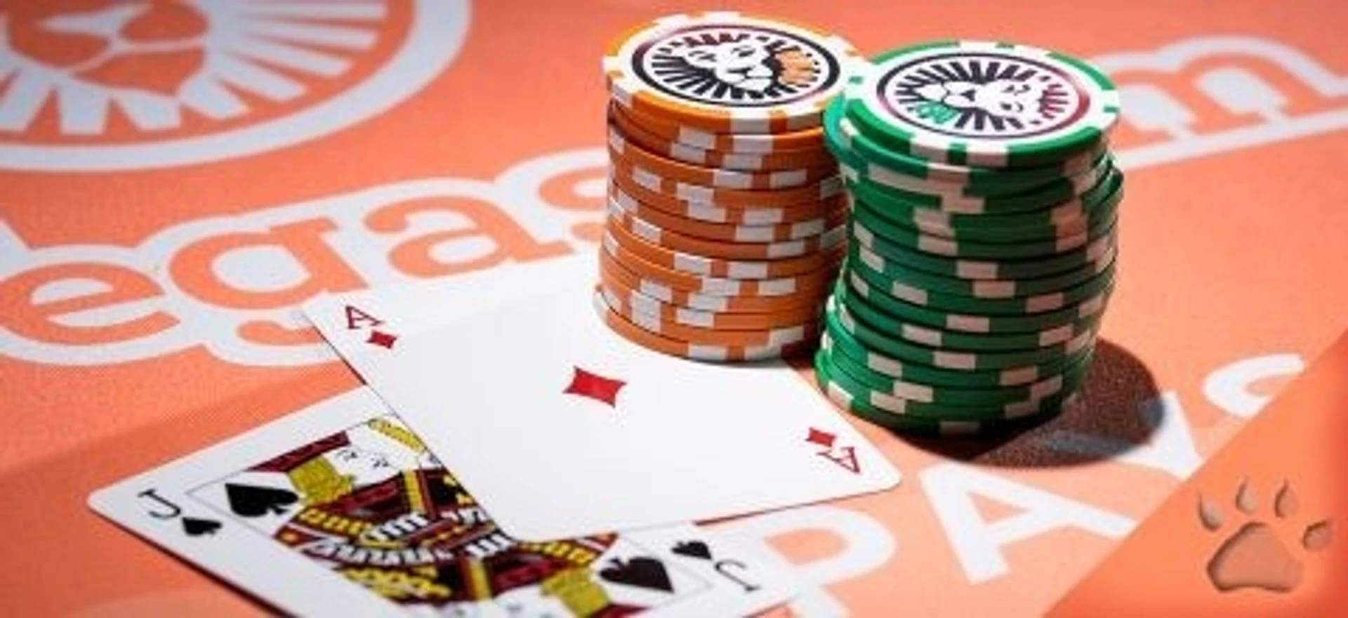 Pokerchips og blackjack-hånd med es og knægt på orange LeoVegas-filt