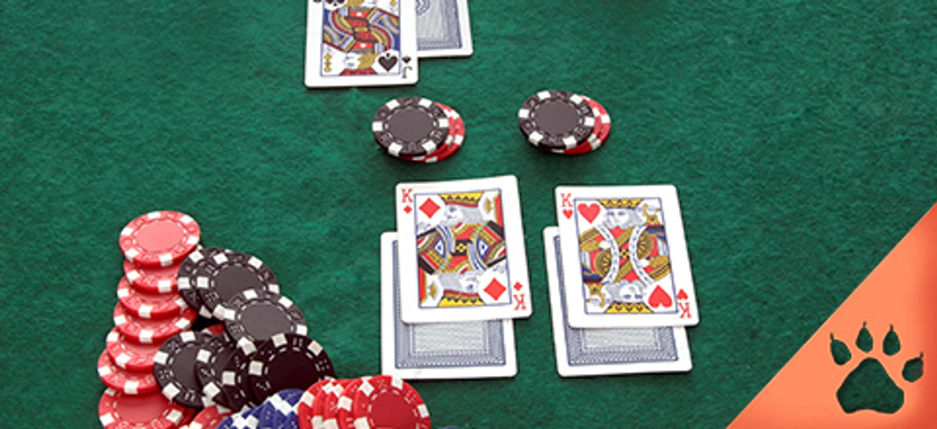 Spillesituation i blackjack med jetoner og to sæt konger lagt på grøn filtdug