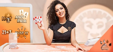 Dealer ved blackjack-bord viser kortene A og J, omgivet af sidebets som '21+3' og 'Bust It