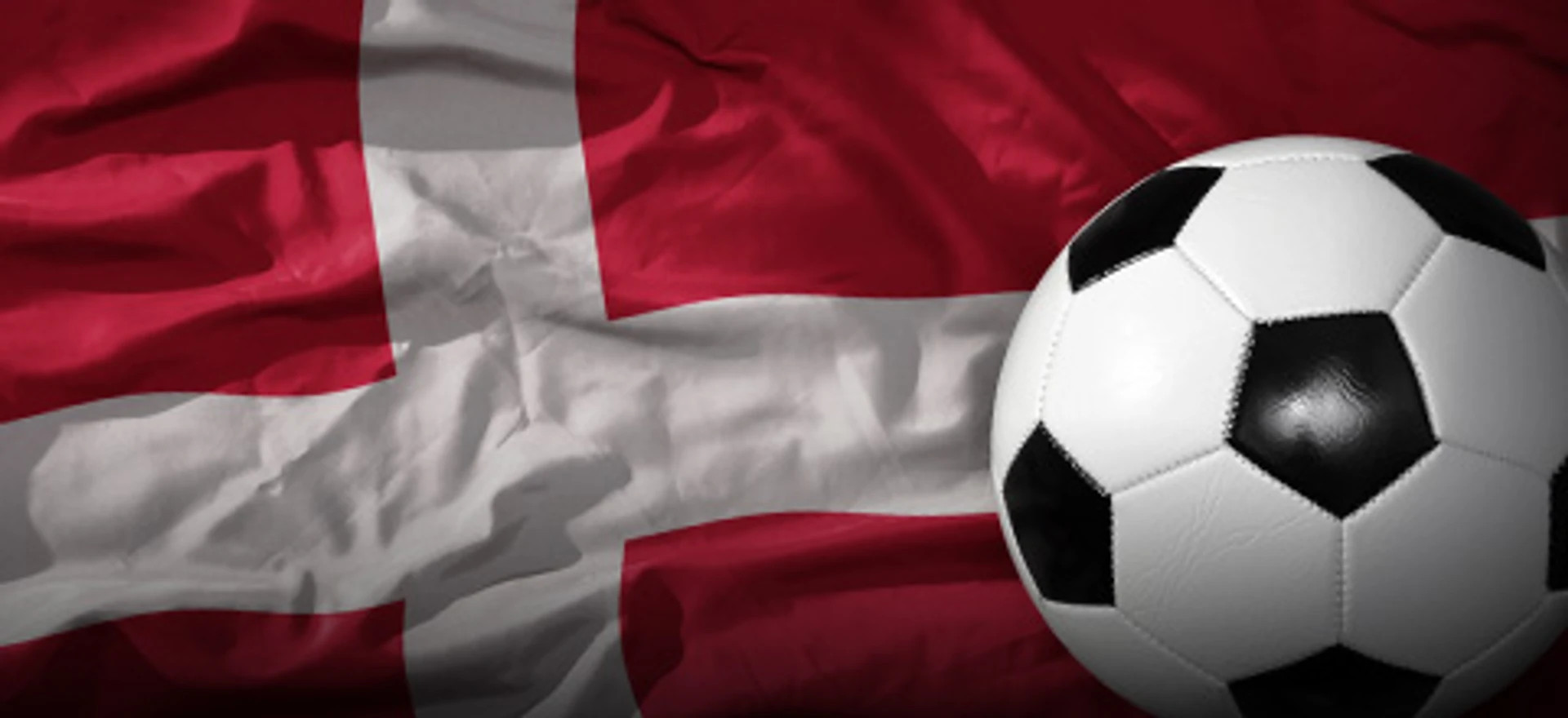 Sort og hvid fodbold foran Dannebrog med bløde folder i stoffet