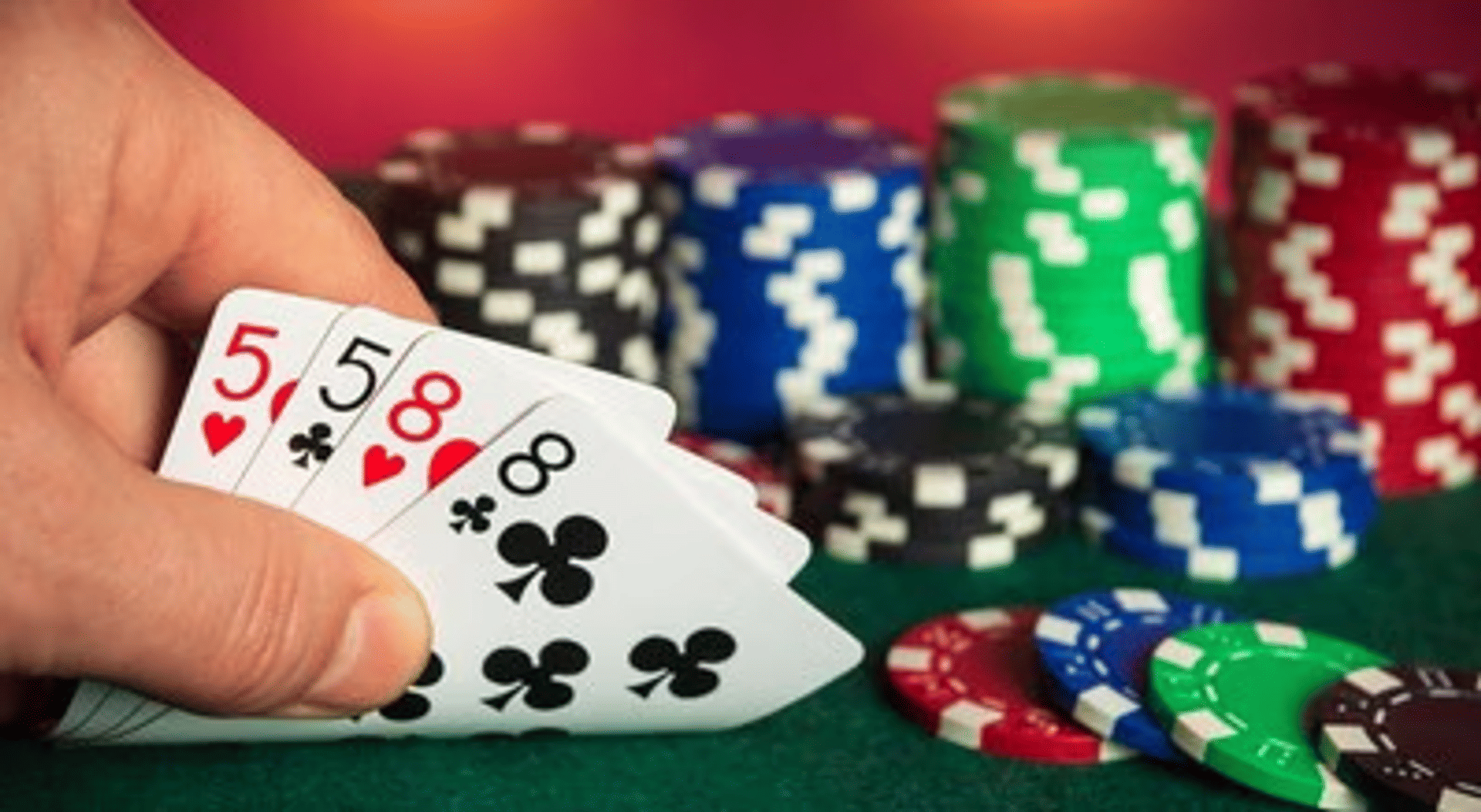 Hånd med poker kort og chips