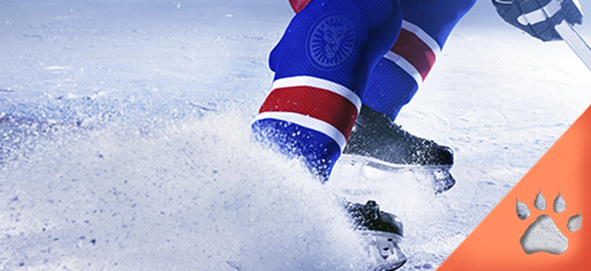 Ishockeyspiller i blå og rød uniform bremser på isen med snefygning og stav i hånden