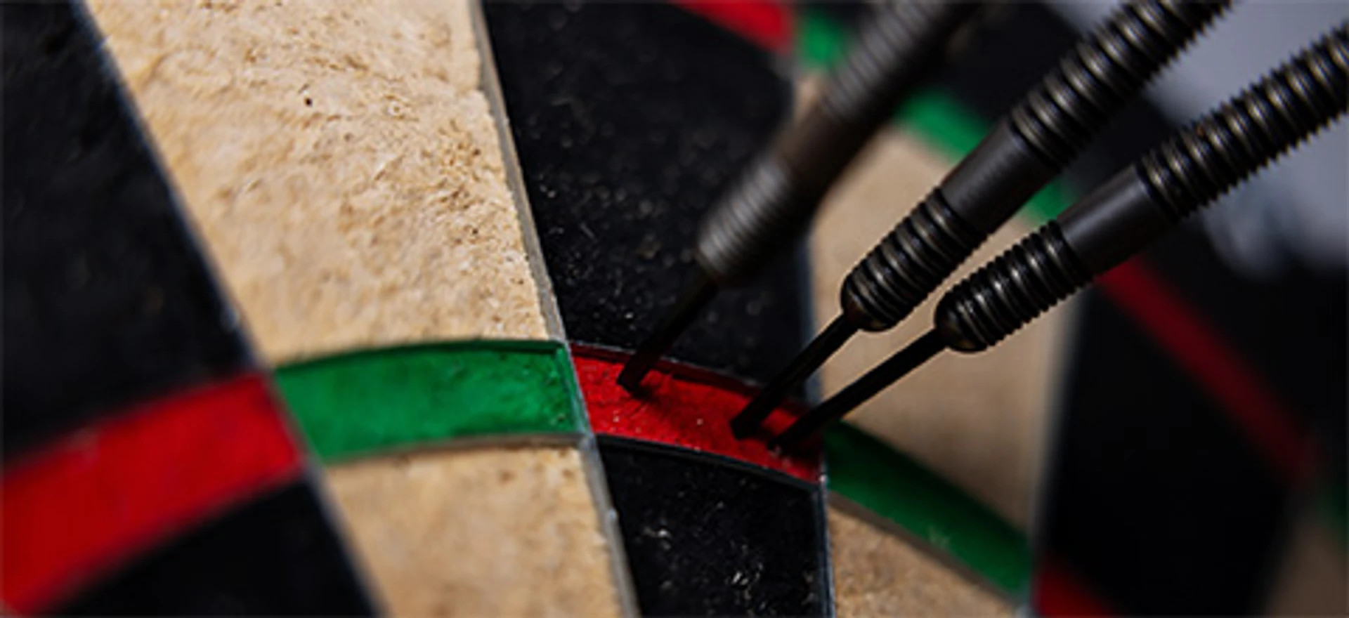 Tre dartpile rammer præcist i den røde treble-sektion på en dartskive