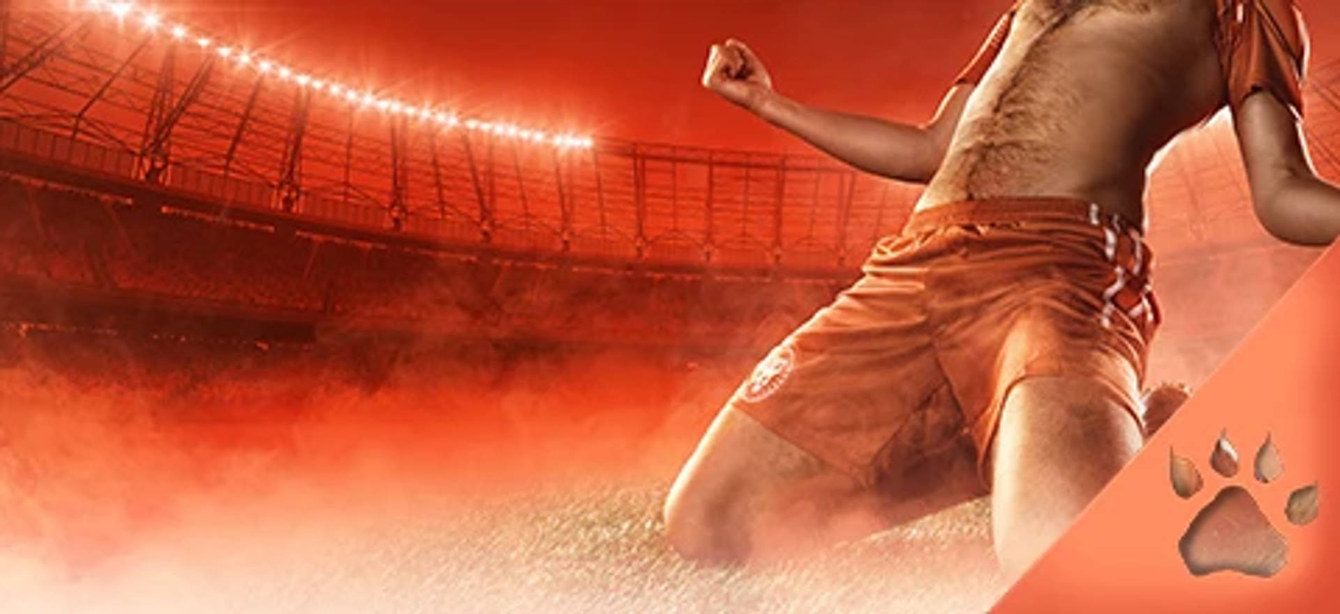 Jalkapalloilija juhlii maalia polvillaan jalkapallo stadiumilla