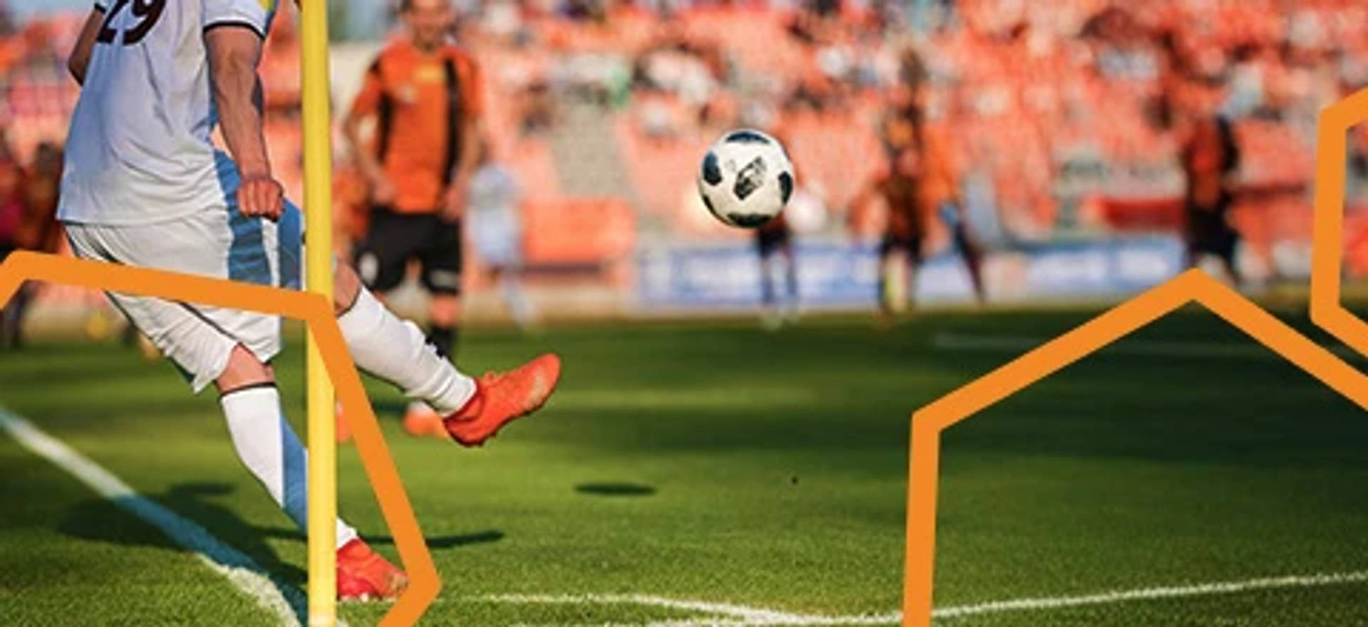 Jalkapalloilija syöttää pallon jalkapallokentän kulmasta