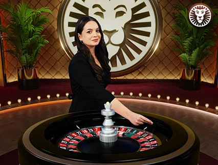 En vit kula släpps ner i ett snurrande roulettehjul av en kvinnlig croupier