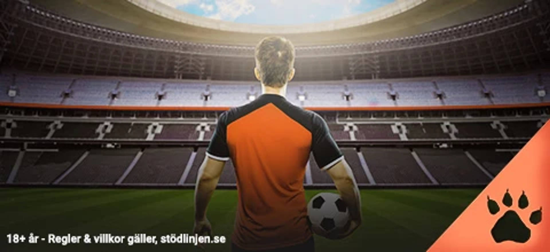 En fotbollsspelare står med bollen under armen och blickar ut över den tomma fotbollsarenan
