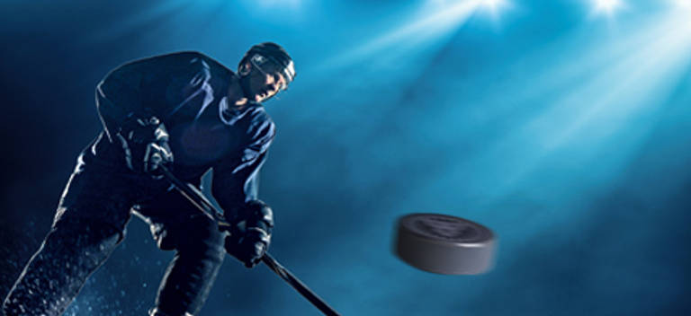 hockey player striking the puck