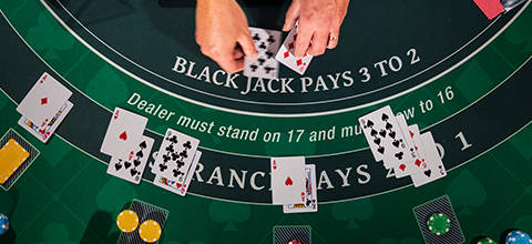Blackjack table with cards and chips; dealer must stand on 17.