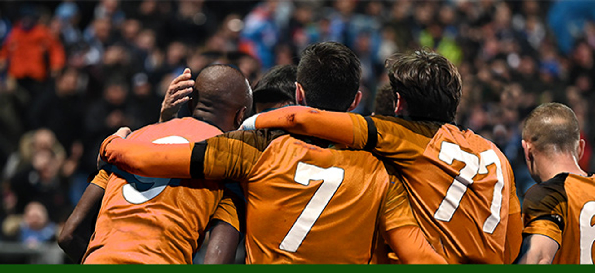 group of football players, hugging.